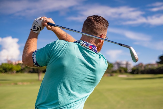 man playing golf on sunny day